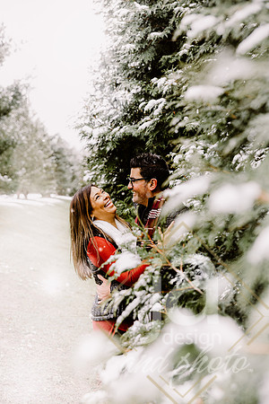 Husband and wife in the snow laughing during their photo session.